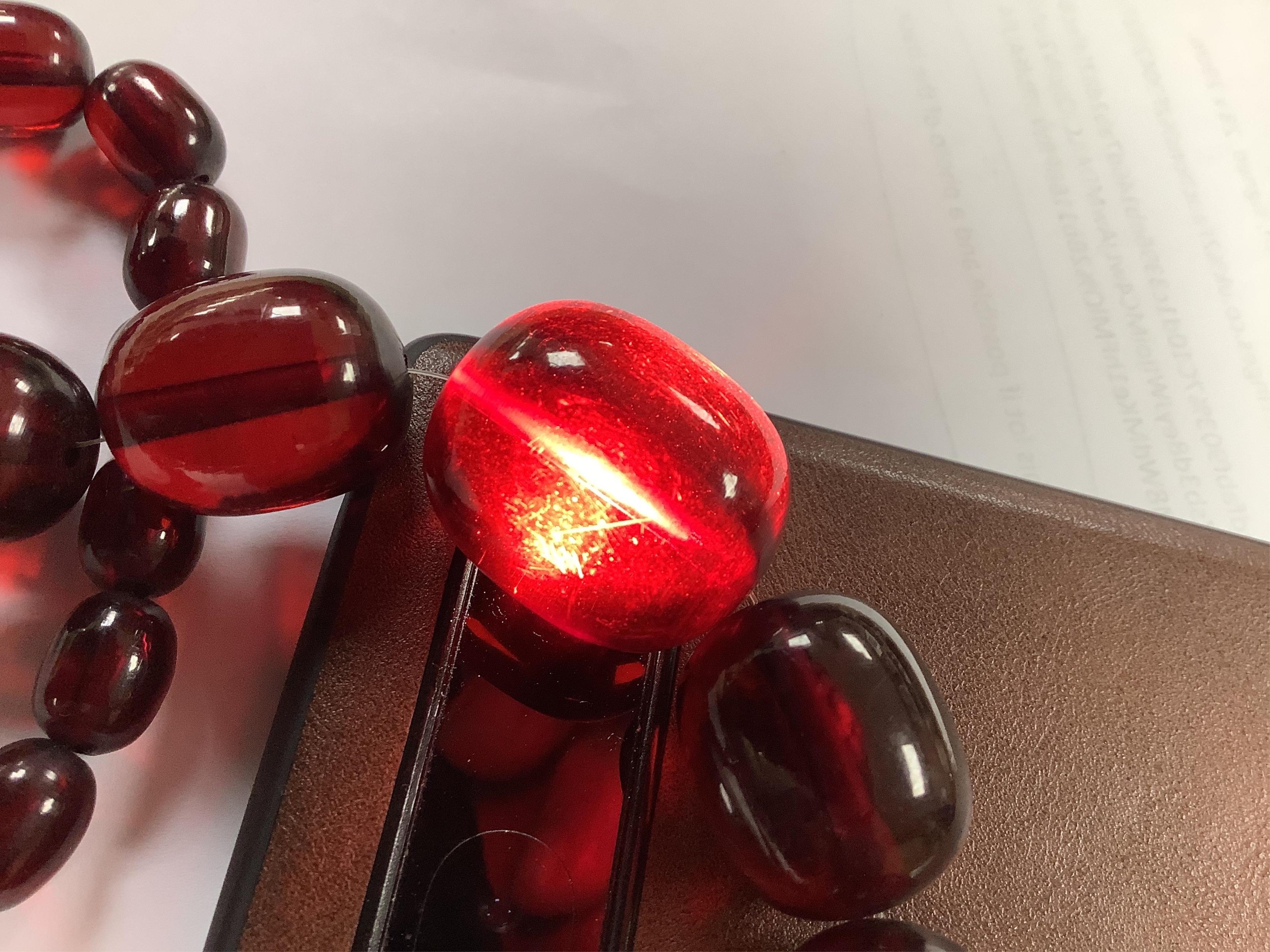 Assorted costume jewellery including simulated cherry amber necklace and simulated coral bead necklace. Condition - poor to fair